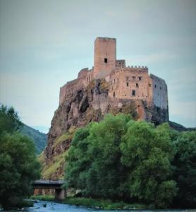 a castle sitting on top of a hill next to a river at Сhachkari in Vardzia