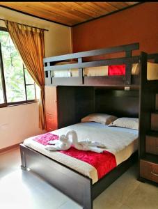 La Casa de la Abuela في Sucúa: غرفة نوم مع سرير بطابقين وعليها بجعتين