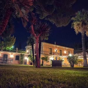 un edificio con palmeras delante de él por la noche en Orlando, quadrupla con bagno privato en Mascalucia