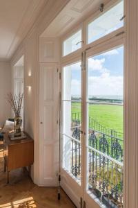 Habitación con una gran puerta de cristal y balcón. en Royal Channel Retreat - Stunning apartment - glorious views, en Kent