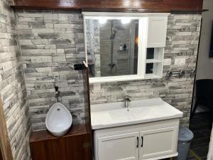 un bagno con lavandino e specchio di Miki Miki House a Fare (Huahine Nui) Altre 27 foto