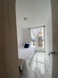 ein weißes Zimmer mit einem Bett und einem Fenster in der Unterkunft Espectacular apartamento amplio y moderno a solo 20 min de termales in Manizales