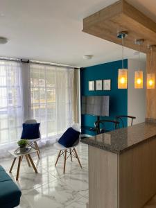 cocina con paredes azules, barra y sillas en Espectacular apartamento amplio y moderno a solo 20 min de termales, en Manizales