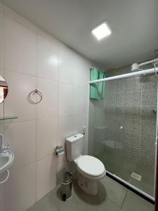 a bathroom with a toilet and a glass shower at Pousada Luz da Lua in Búzios