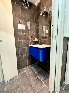 ein Badezimmer mit einem blauen Waschbecken und gefliesten Wänden in der Unterkunft Yacht Club Angioino in Neapel