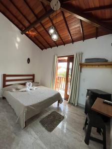 a bedroom with a bed and a wooden ceiling at Pousada Luz da Lua in Búzios