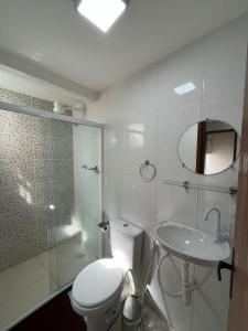 a bathroom with a toilet and a sink and a shower at Pousada Luz da Lua in Búzios