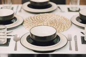 una mesa con platos en blanco y negro y cubiertos en Luxe Spacious & Central 2Bed Luton Apartment - Free Parking - Free Wi-Fi - Near LTN Airport & L&D Hospital, en Luton