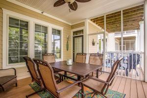 a porch with a wooden table and chairs at Bear Trap Dunes - 124G October Glory in Ocean View