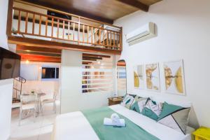 a bedroom with a bed and a kitchen with a balcony at Solar Água Pipa- Summer Pipa in Pipa