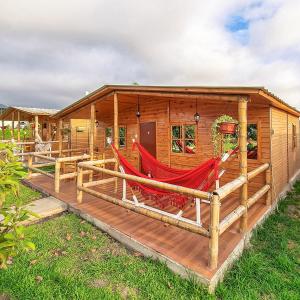a log cabin with hammocks on the deck at Apart Hotel El Paraíso de Barranca in Barranca