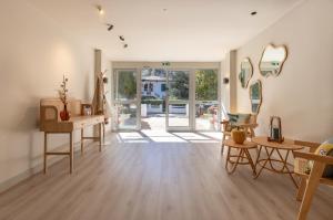 a living room with wooden floors and large windows at Résidence Maminotte in La Teste-de-Buch