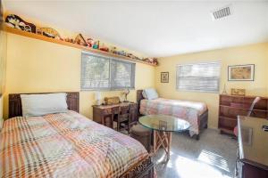a bedroom with two beds and a desk and a table at Oasis on Siesta Key in Sarasota
