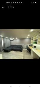a living room with a couch and a desk at Двухкомнатная квартира в самом центре Актобе in Aktobe +3 photos
