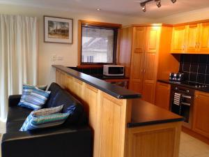 a living room with a couch and a kitchen at The Villa On Pine Tree in Grindelwald