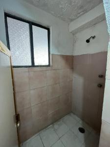 La salle de bains est pourvue d'une douche et d'une fenêtre. dans l'établissement Hotel Jorges Morelia, à Morelia