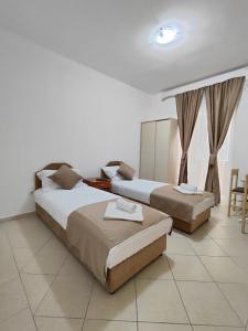 a hotel room with two beds and a table at Villa Hera in Budva
