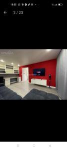 阿克托比的住宿－Двухкомнатная квартира в самом центре Актобе，客厅设有红色的墙壁和平面电视。