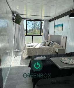 - une chambre avec 2 lits et une table dans l'établissement Greenboxaparts, à Firmat
