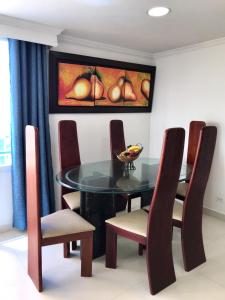 uma sala de jantar com uma mesa de vidro e cadeiras em Apartamento totalmente equipado a media cuadra de la playa del Laguito em Cartagena das Índias
