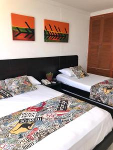 duas camas sentadas uma ao lado da outra num quarto em Apartamento totalmente equipado a media cuadra de la playa del Laguito em Cartagena das Índias