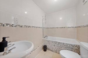 Baño blanco con lavabo y bañera en Sleeps 5 - Large Garden - Wifi, en Kent