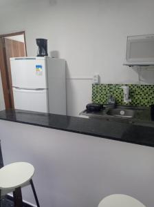 a kitchen with a white refrigerator and a sink at KITNET MOBILIADA - PENHA in Rio de Janeiro