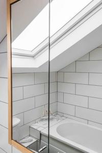 a bathroom with a glass shower with a tub at Seascape - Modern one bedroom, two storey annexe in Kent