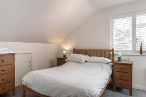 Seascape - Modern one bedroom, two storey annexe في Kent: غرفة نوم بسرير وليلتين موقف ونافذة