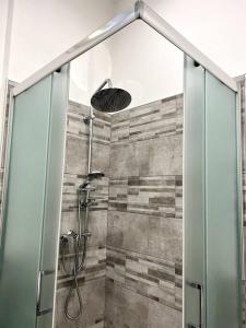 La salle de bains est pourvue d'une douche avec une porte en verre. dans l'établissement Grano - appartamento Lecce centro, à Lecce