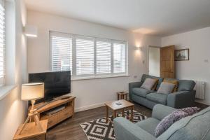 a living room with a couch and a tv at Seascape - Modern one bedroom, two storey annexe in Kent