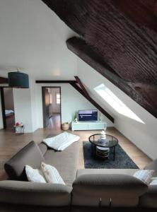 - un salon avec un canapé et une table dans l'établissement Beau duplex au pied des Vosges, à Uffholtz