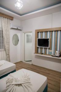 a room with two beds and a flat screen tv at Amsterdam Otel Economic Room in Kemer