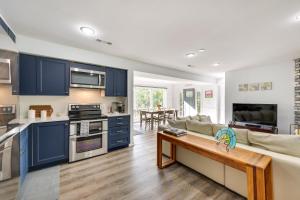 een keuken en een woonkamer met blauwe kasten en een bank bij Waterfront Eureka Springs Vacation Rental with Deck in Eureka Springs