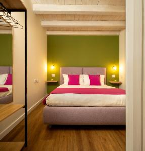 um quarto com uma cama com uma parede verde em The Room Ortigia em Siracusa