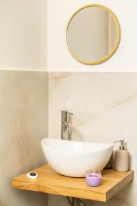 uma casa de banho com um lavatório branco e um espelho. em The Room Ortigia em Siracusa