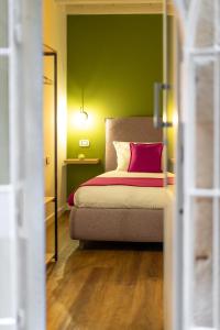 um quarto com uma cama com uma parede verde em The Room Ortigia em Siracusa