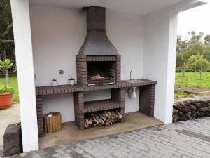 a outdoor fireplace is shown in a patio at Ti Chôa - Casa da Mata in Angra do Heroísmo