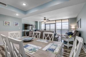 een eetkamer en een woonkamer met een tafel en stoelen bij South Wind 902 in Myrtle Beach