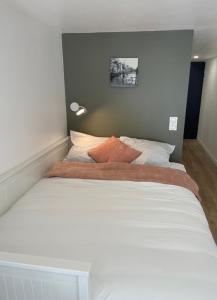 sypialnia z dużym łóżkiem z białą pościelą w obiekcie "Silk & Suites" City Center w mieście Saint-Étienne