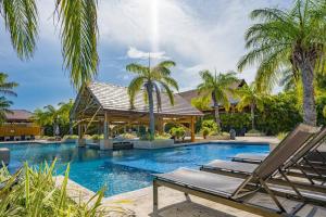 una piscina con 2 tumbonas y palmeras en Bristol Lake House - Private Pool - King Beds - Next to El Faro Beach Club en Boca de Río Hato