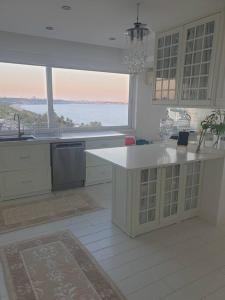 a kitchen with a sink and a large window at Antalya Konyaaltı Plajında dublex GEMİ EV in Antalya