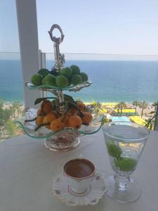 a table with a plate of fruit and a bowl of oranges at Antalya Konyaaltı Plajında dublex GEMİ EV in Antalya