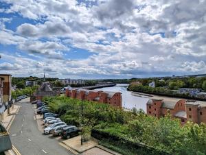 een parkeerplaats met auto's geparkeerd naast een rivier bij Quayside apartment with riverside views & parking in Newcastle upon Tyne