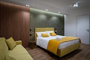 a bedroom with a large bed and a couch at Sofi' Center Rooms in Sciacca