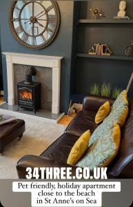 a living room with a couch and a clock at 34Three in Lytham St Annes