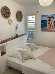 a bedroom with a bed and a window at Villa Paradis - vue mer, piscine et jacuzzi in Sainte-Anne
