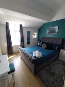 um quarto com uma cama grande e uma colcha azul em 34Three em Lytham St Annes