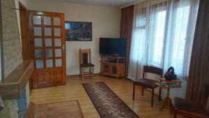 Vitosha Guest House في ديفين: غرفة معيشة مع تلفزيون بشاشة مسطحة وغرفة معيشة مع تلفزيون