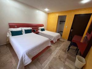a hotel room with two beds and a desk at Capital DF Inn in Mexico City